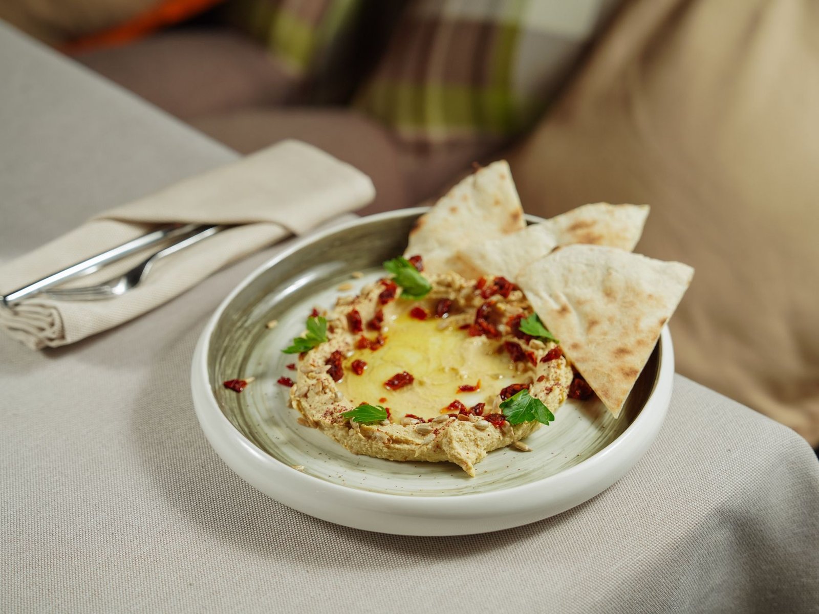 A plate of hummus served with pita bread and vegetables