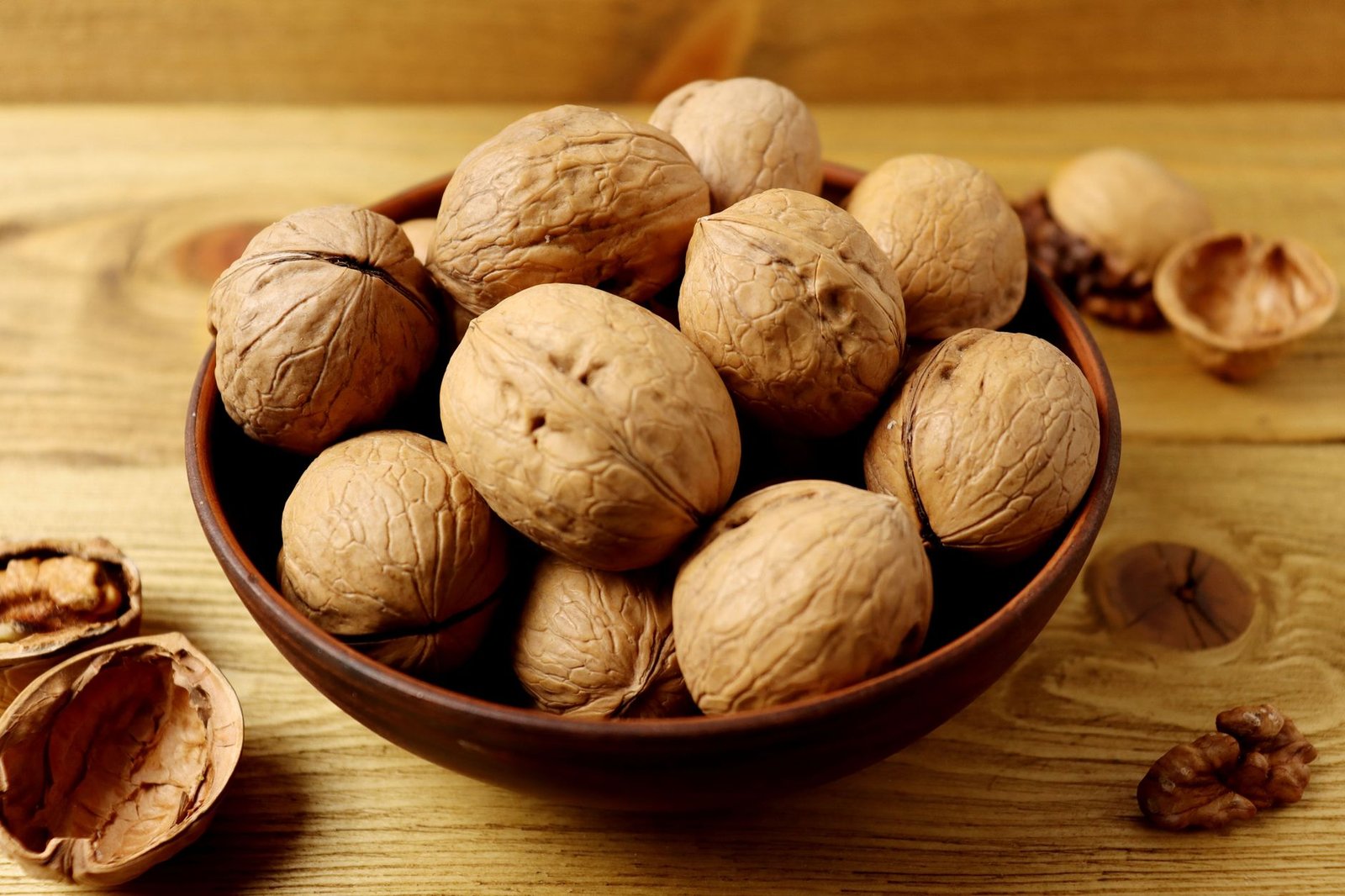 A bowl of walnuts on a wooden table