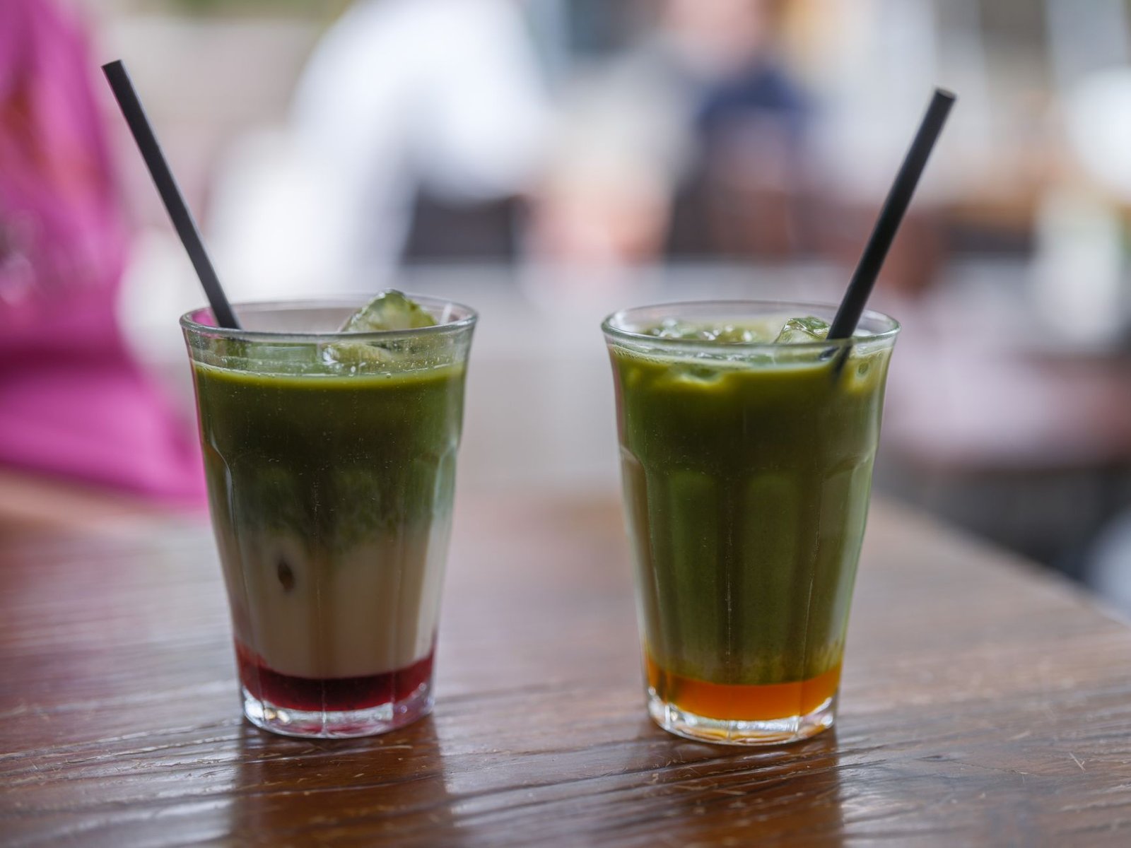 A visually appealing layered smoothie featuring matcha and seasonal fruits