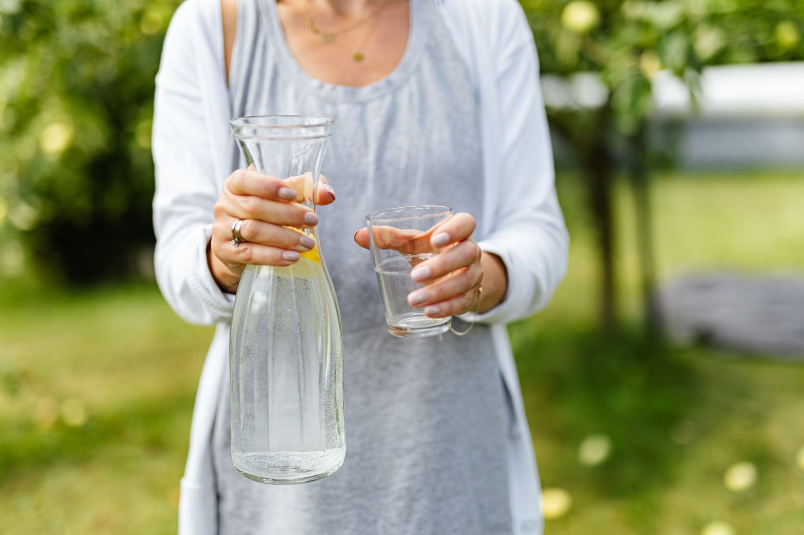 Image of a person enjoying a glass of lemon water