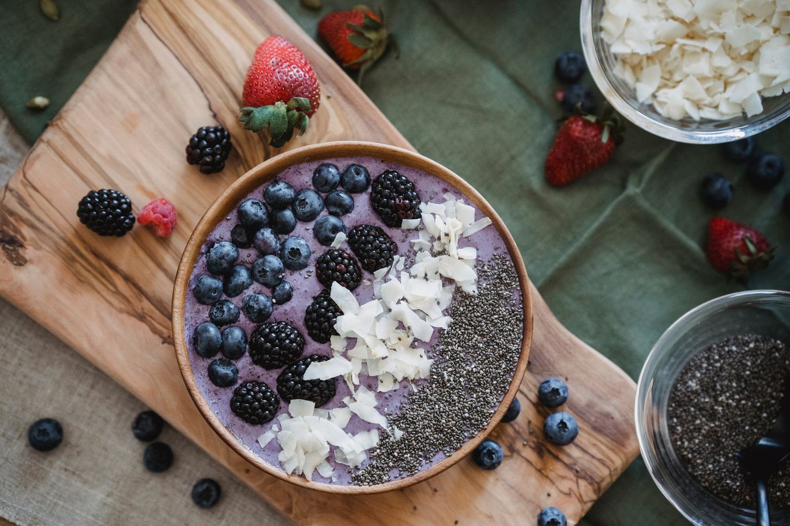 A vibrant green matcha smoothie bowl topped with fruits and nuts